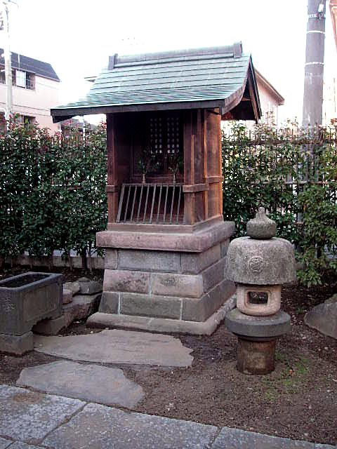 木造の小祠と石灯籠。稲荷舎