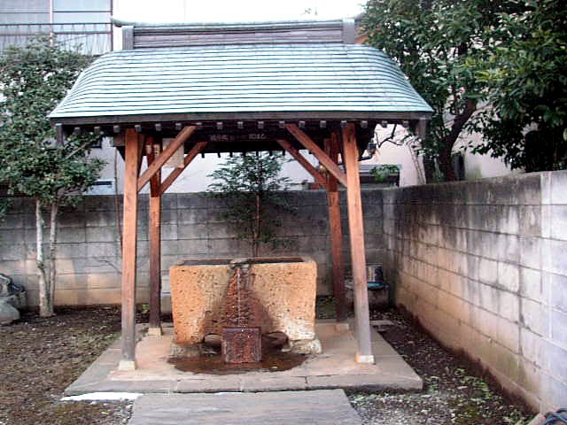 瓦屋根の水屋。中央に石の水盤